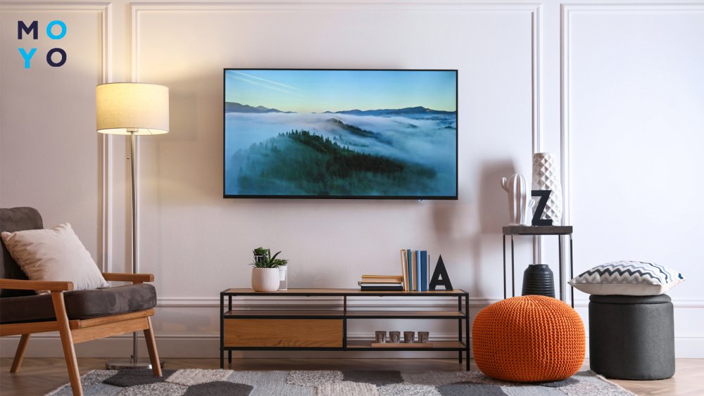 Большой телевизор висит на стене в комнате