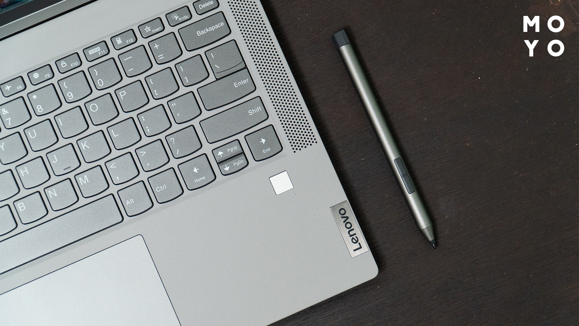 сірий олівець лежить поряд із ноутбуком Lenovo
