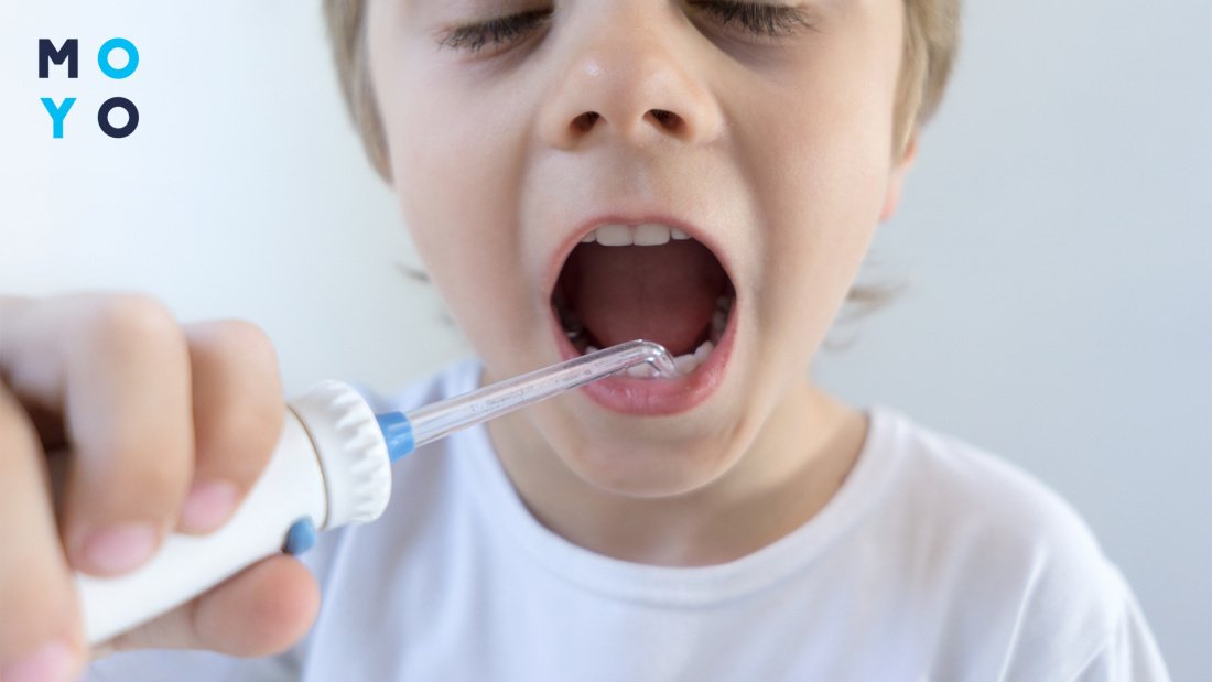 Ребенок чистит зубы с помощью ирригатора