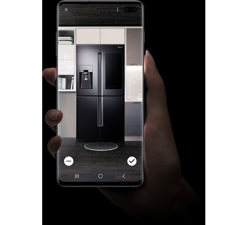 Image of a hand holding Galaxy S10 plus with Bixby Visionâs Apps mode Home Decor feature onscreen. Itâs showing a Samsung refrigerator in a kitchen.